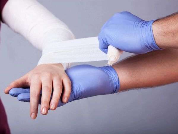 Paramedic Making a Bandage for Woman