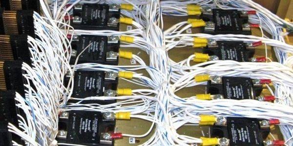 Rows of black electronic modules interconnected with white wires.