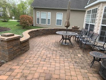 Brick patio with outdoor furniture and umbrella.