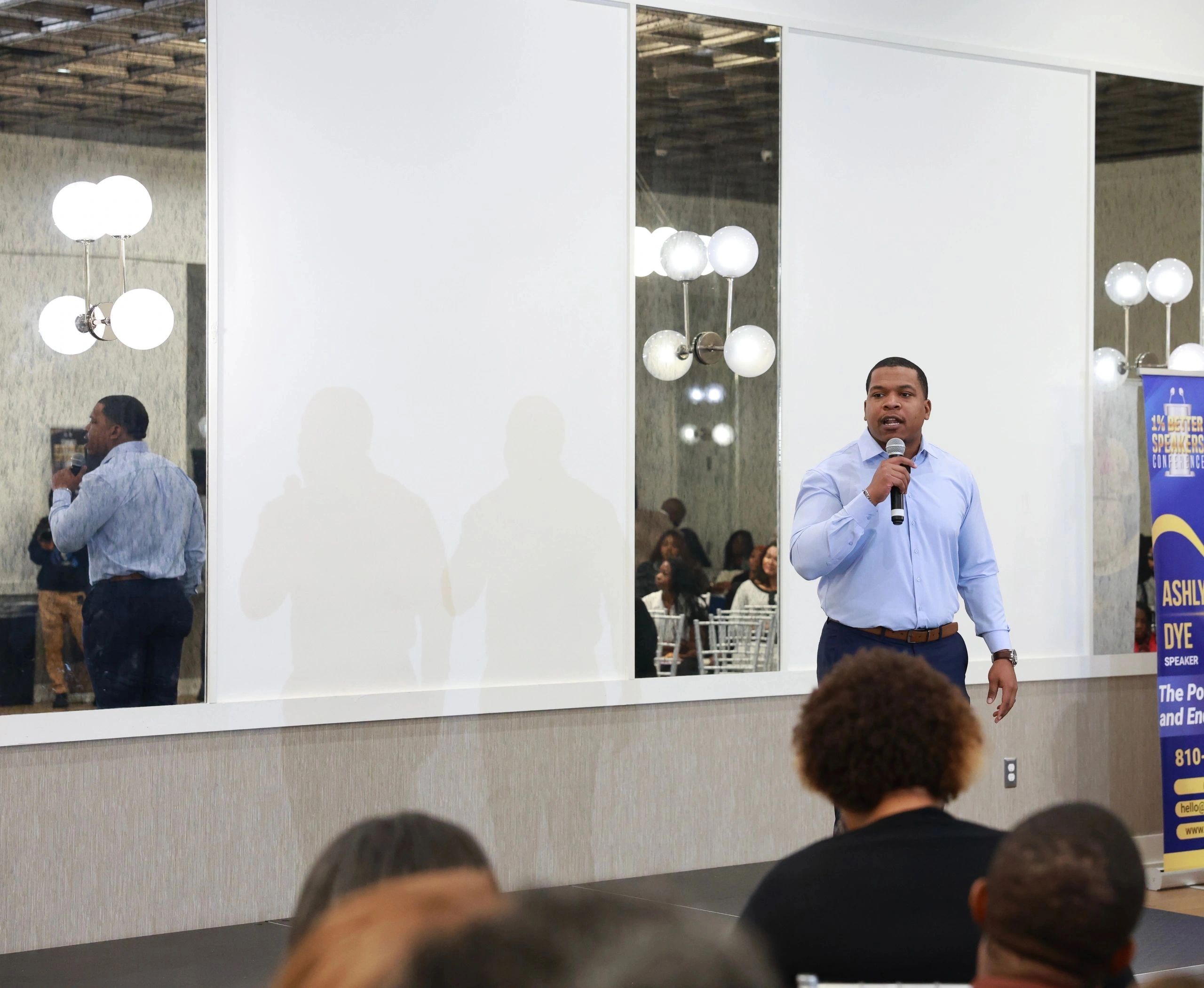 A man speaking at a conference with an audience.