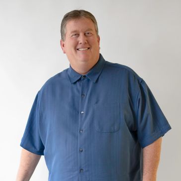 Smiling man wearing a blue shirt.