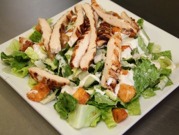 Grilled chicken Caesar salad with romaine, croutons, and dressing.