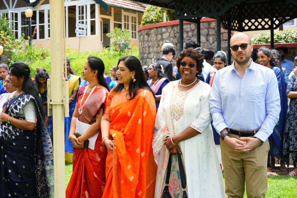 Group of people smiling and mingling outdoors at an event.