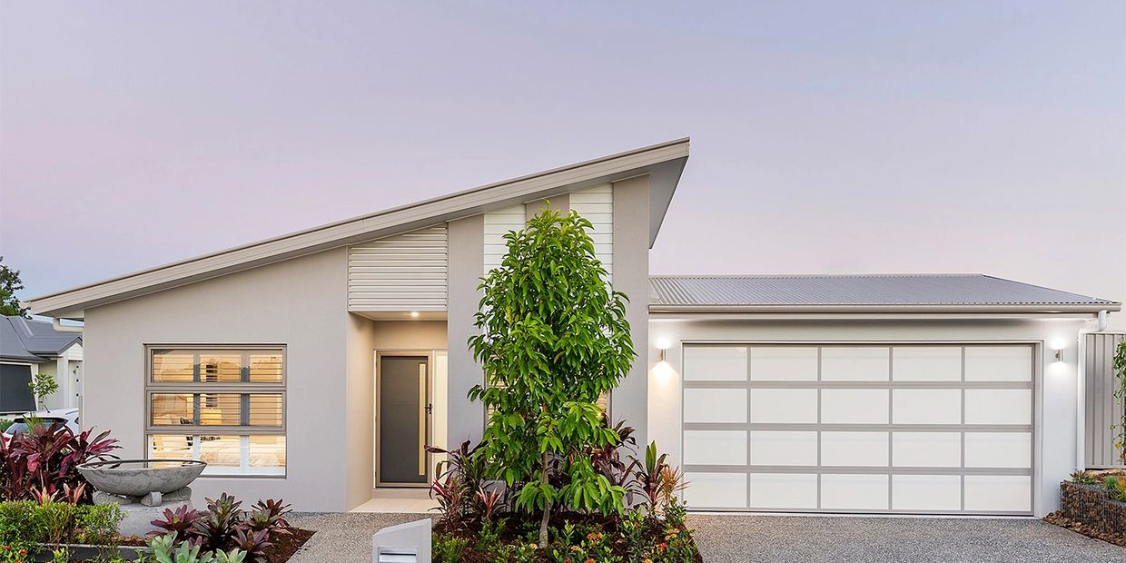 Modern house with slanted roof and well-maintained front garden.