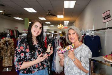 Two woman holding the floral sandals 
