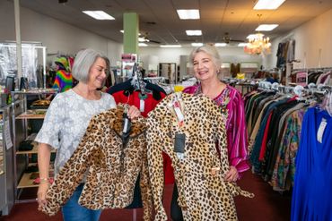 Woman Holding cheetah print dress and sweater 