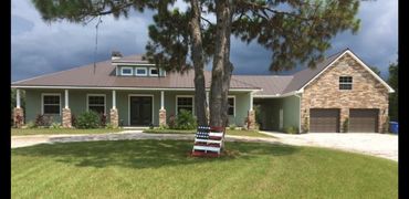 Modern house with stone accents and an American flag decoration on a tree.