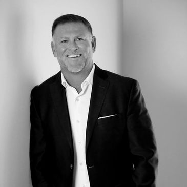 Man in a suit smiling at the camera.