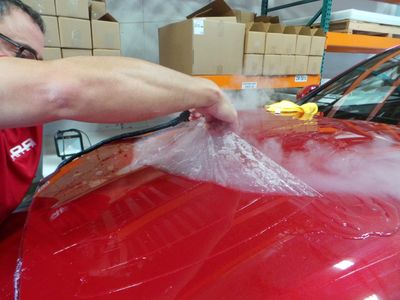 a man waxing a red color car