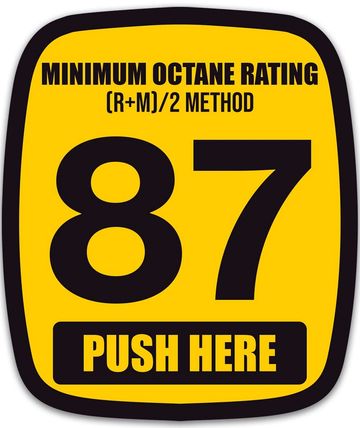 Yellow sign showing minimum octane rating 87 with push here instruction.
