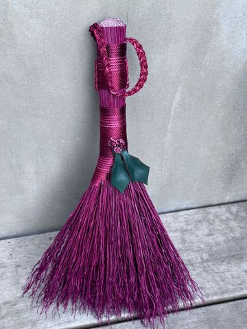 Decorative purple broom with green leaves and berries.