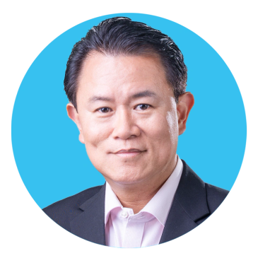 Professional headshot of a man in a suit with a blue background.