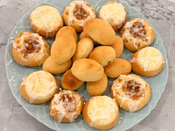 A plate of assorted baked breads and sweet rolls with icing.