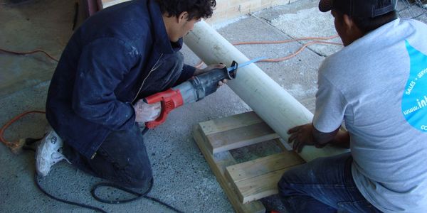 Interpool team members working together on pool plumbing at a job site.