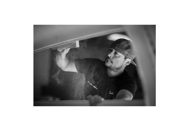 grey scale photo shows the owner of color wheel collision refinishing a vehicle in shop