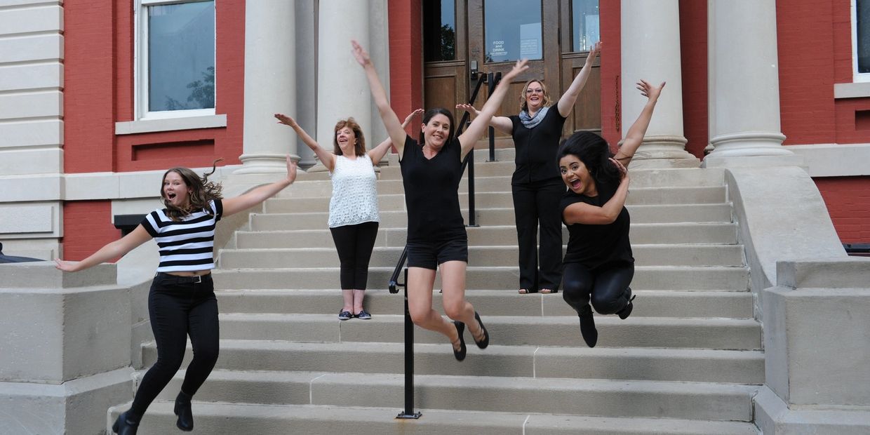 A group of dance teachers jumping off the steps 