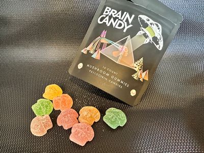 Colorful Brain Candy mushroom gummies scattered near the package.
