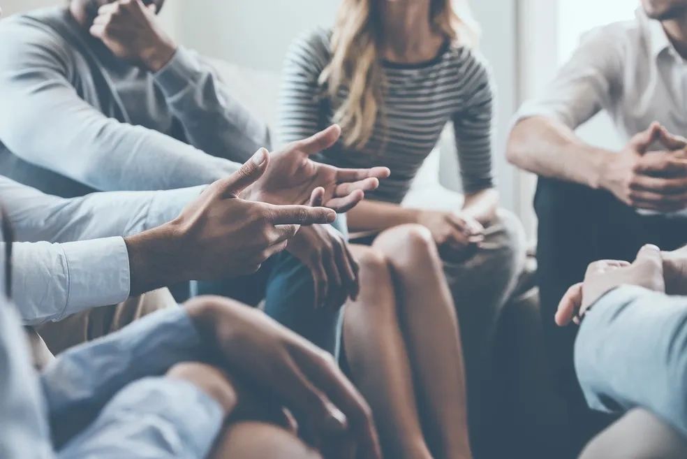 Group in discussion with expressive hand gestures.