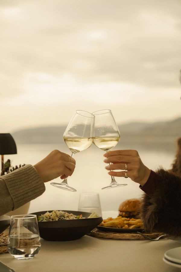 göl manzarası eşliğinde alakart restaurant alanında özel gün etkinliğini şarap ile kutlayan çift 