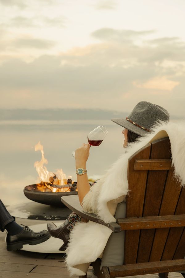 sapanca gölü kıyısında bulunan iskelede ateş başında şarap içerek keyifli vakit geçiren çift