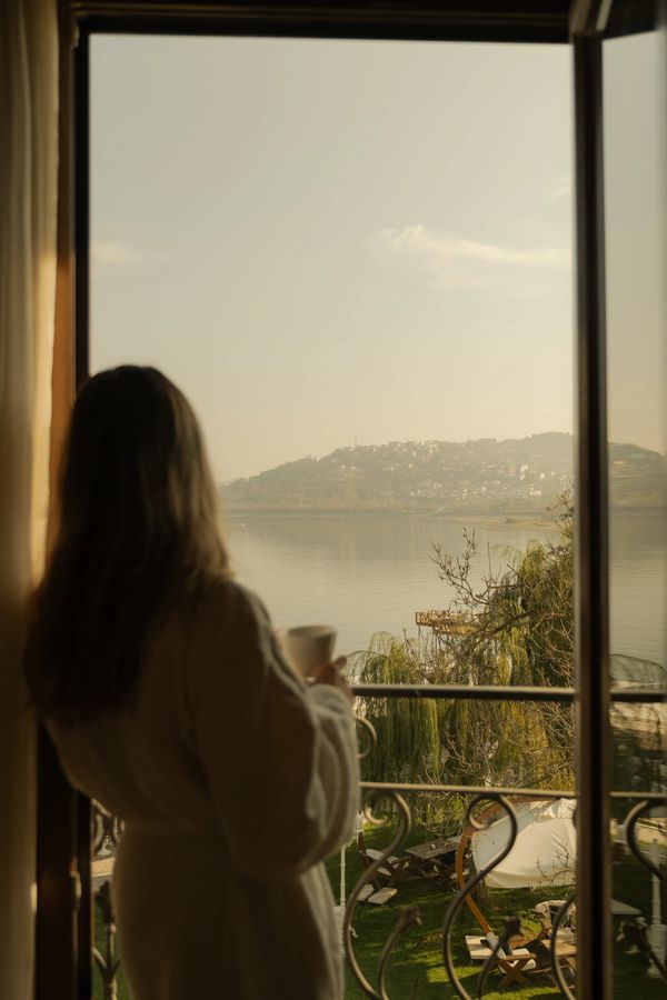 sapanca gölü kenarında otel odası pencere önünde manzara eşliğinde kahve yudumlayarak güne başlamak 