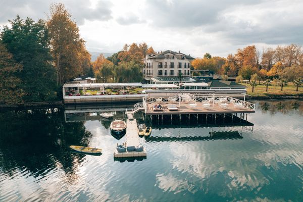 Göl kenarında butik bir otel iskelesi ve iskeleye bağlı kano ve tekne