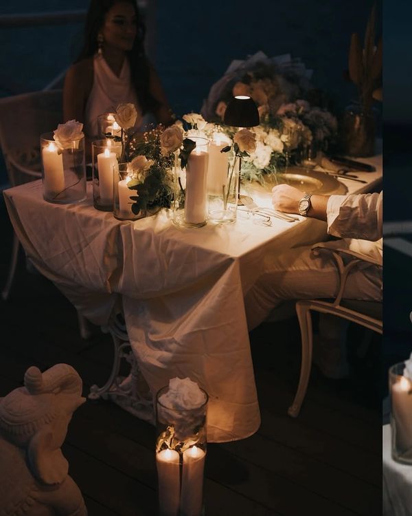 sapanca gölü kenarında bulunan iskelede mumlar eşliğinde akşam yemeği yiyen çift 