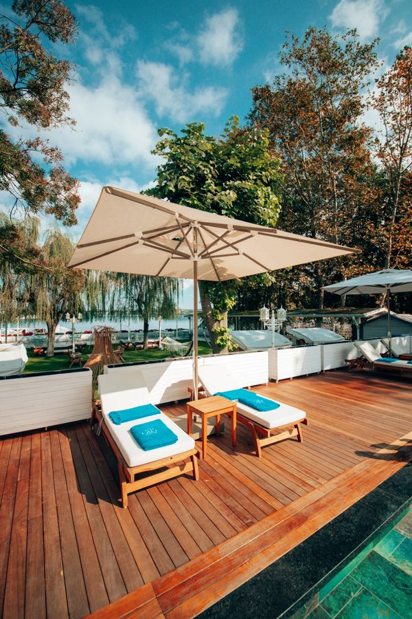 Havuz kenarında ahşap iki şezlong ve mavi havlular