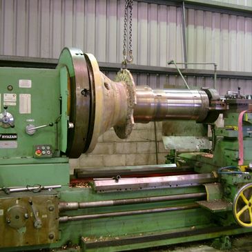 Large earthmoving wheel spindle being machined for thermal spray in 8m lathe