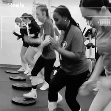 Group of women exercising together in a gym setting.