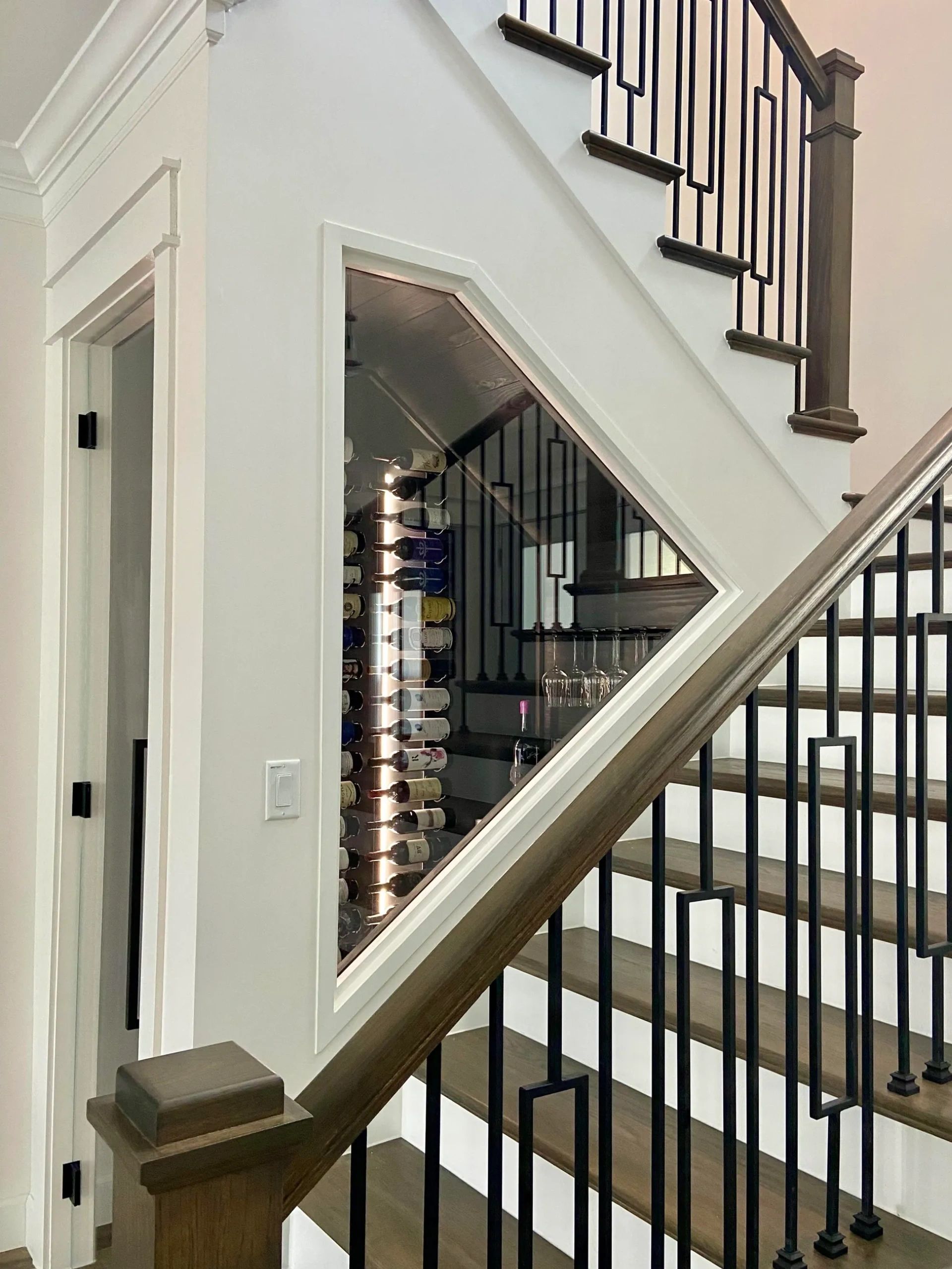 Under stair wine display with bottles and glassware