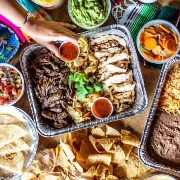 Mexican feast with grilled meats, tortillas, and sides.