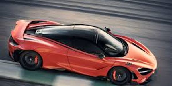 Sleek orange sports car speeding on a racetrack.