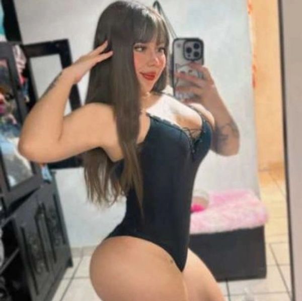 Woman taking a mirror selfie in black lingerie.