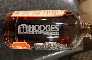 A glass bottle labeled Hodges Window &amp; Glass.