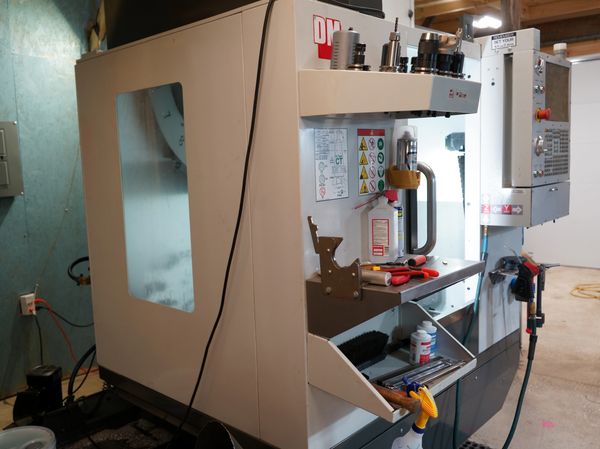 Industrial CNC machining center with tools and control panel.