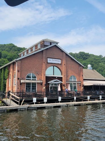 Brick building named Ole Savannah by the water with outdoor seating.