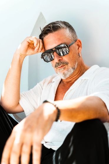 Hombre con gafas de sol y barba blanca.