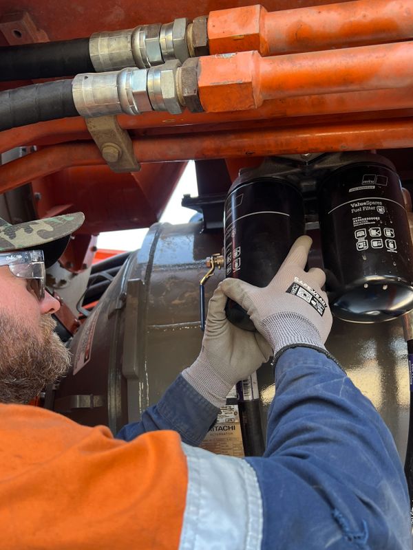 Worker inspecting and handling industrial fuel filters.