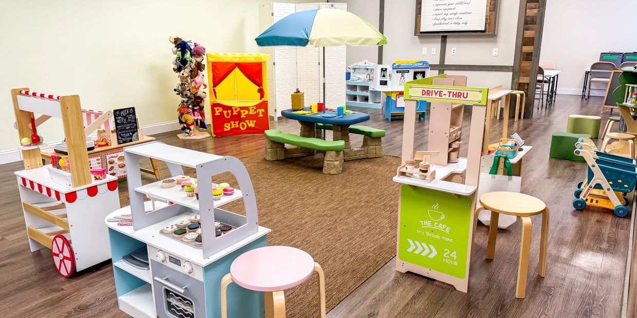 Colorful children's playroom with various activity stations and toys.