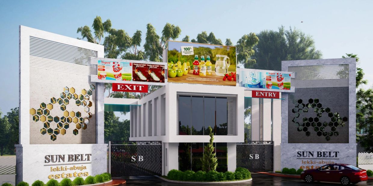 Entrance and exit gates of Sun Belt Lekki-Abuja Estates with billboards and greenery.