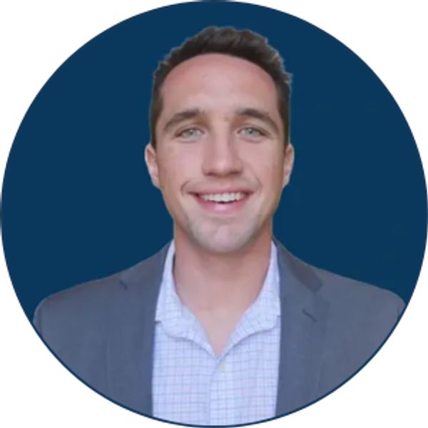 Smiling man in a suit against a blue background.