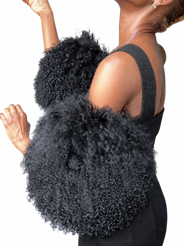 Woman wearing a black dress with dramatic fluffy sleeves.