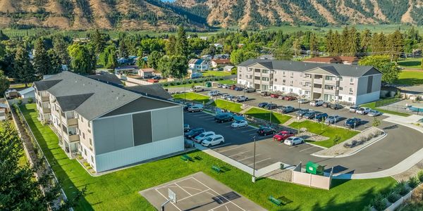Aerial view of apartment buildings with parking and basketball court.