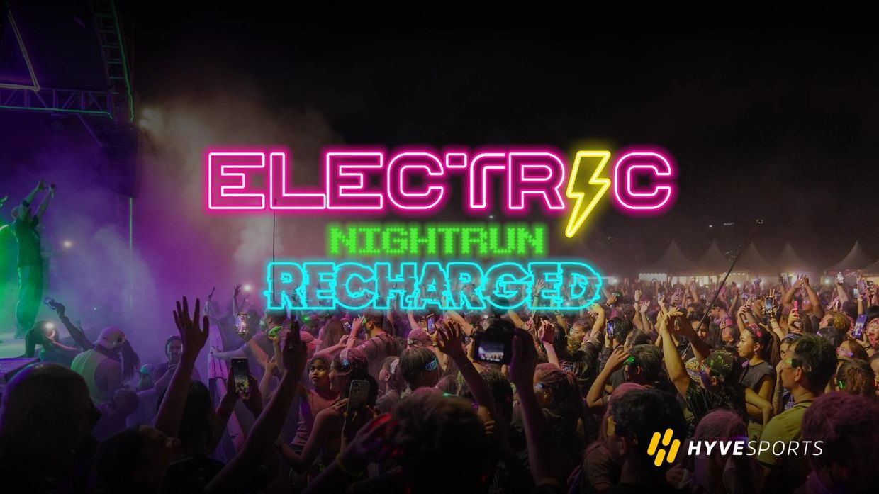 Crowd enjoying the Electric Night Run Recharged event with vibrant neon lights.