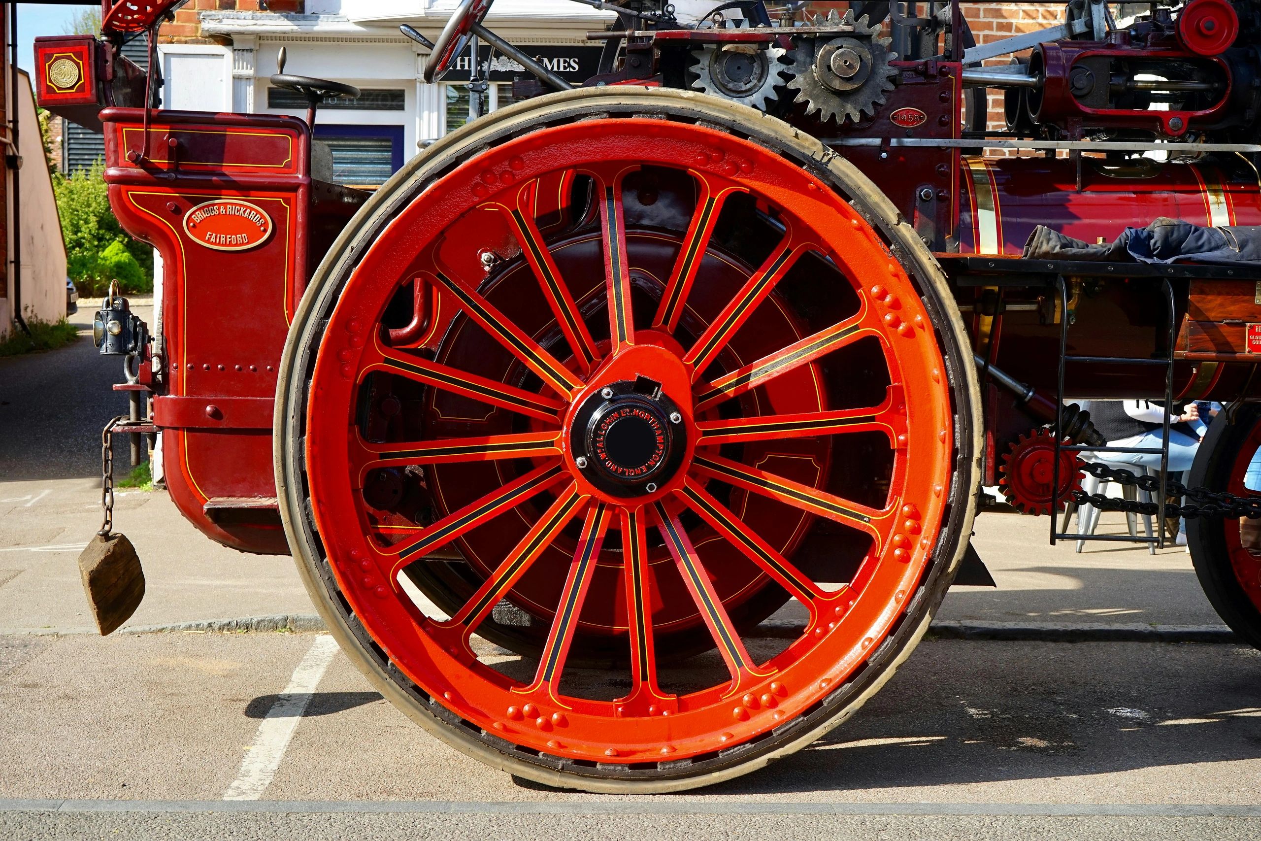 Close-up of a bright red vintage steam tractor wheel.