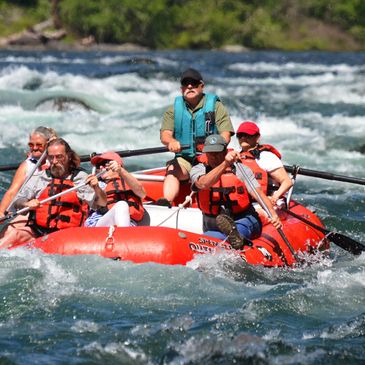 Bob Spencer steers a red paddle assist raft with five paddlers through Marten Rapid on the McKenzie 