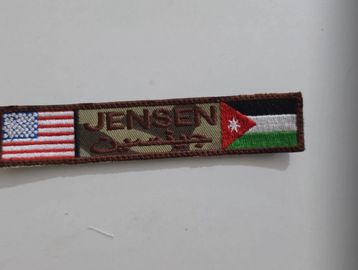A military-style patch with American and Jordanian flags and the name Jensen.