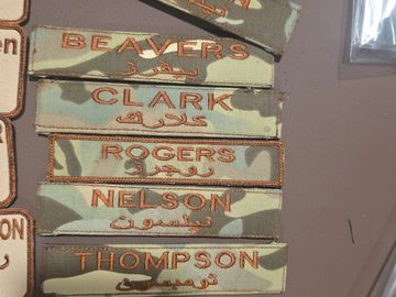 Military name patches with camouflage background and orange text.