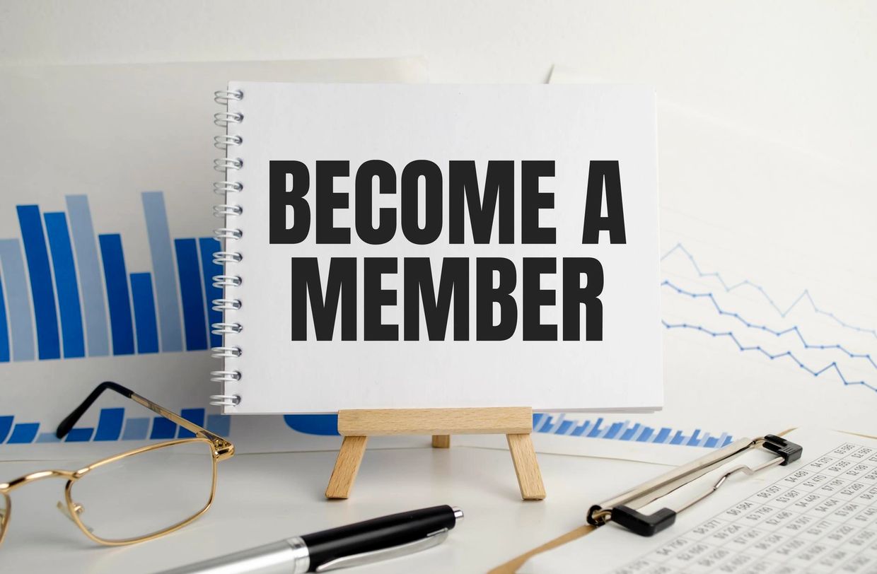 "Become a member" sign sitting on an easel with bar charts in the background.  